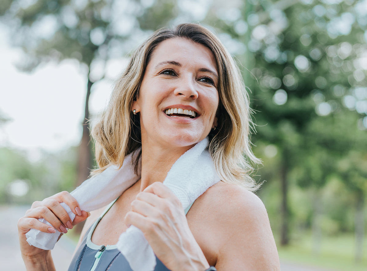 Mujer madura sonriente tras hacer ejercicio al aire libre